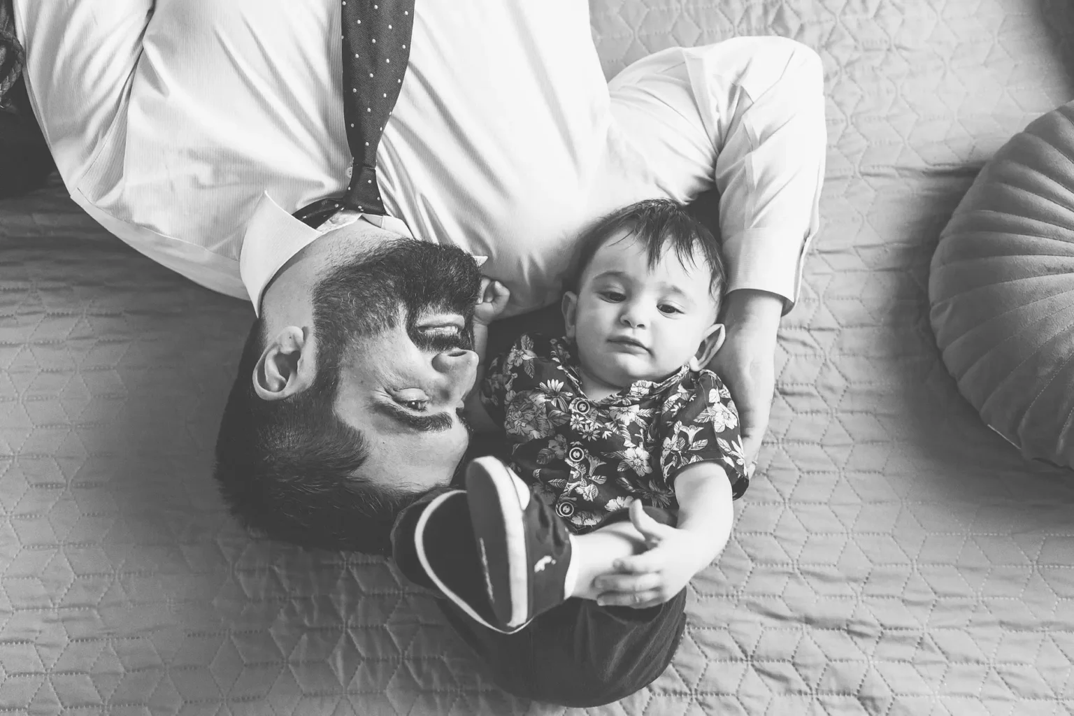 a man lying on a bed with a baby