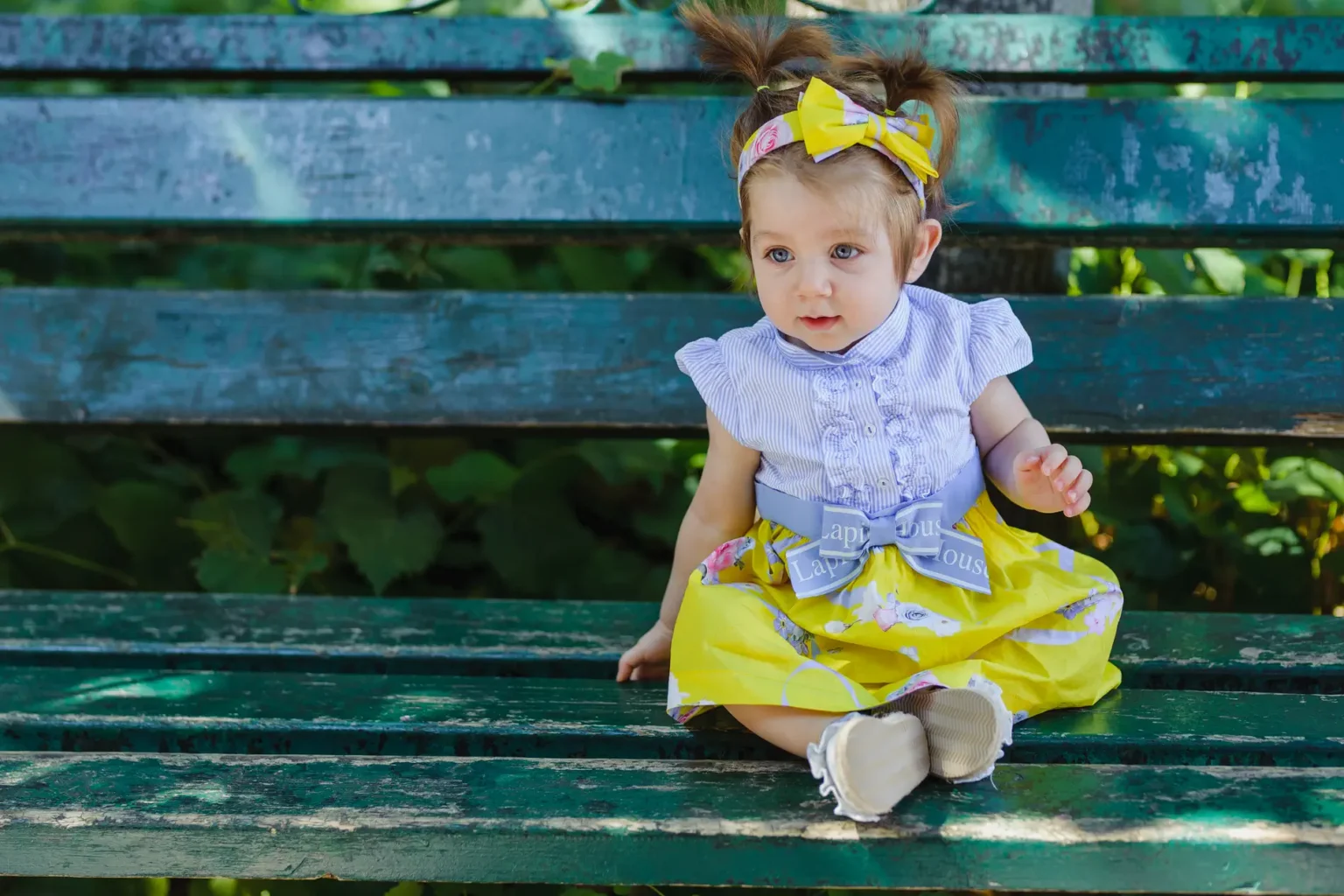 a baby sitting on a bench