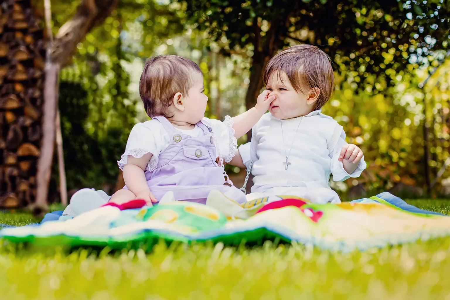 a baby touching another baby's nose