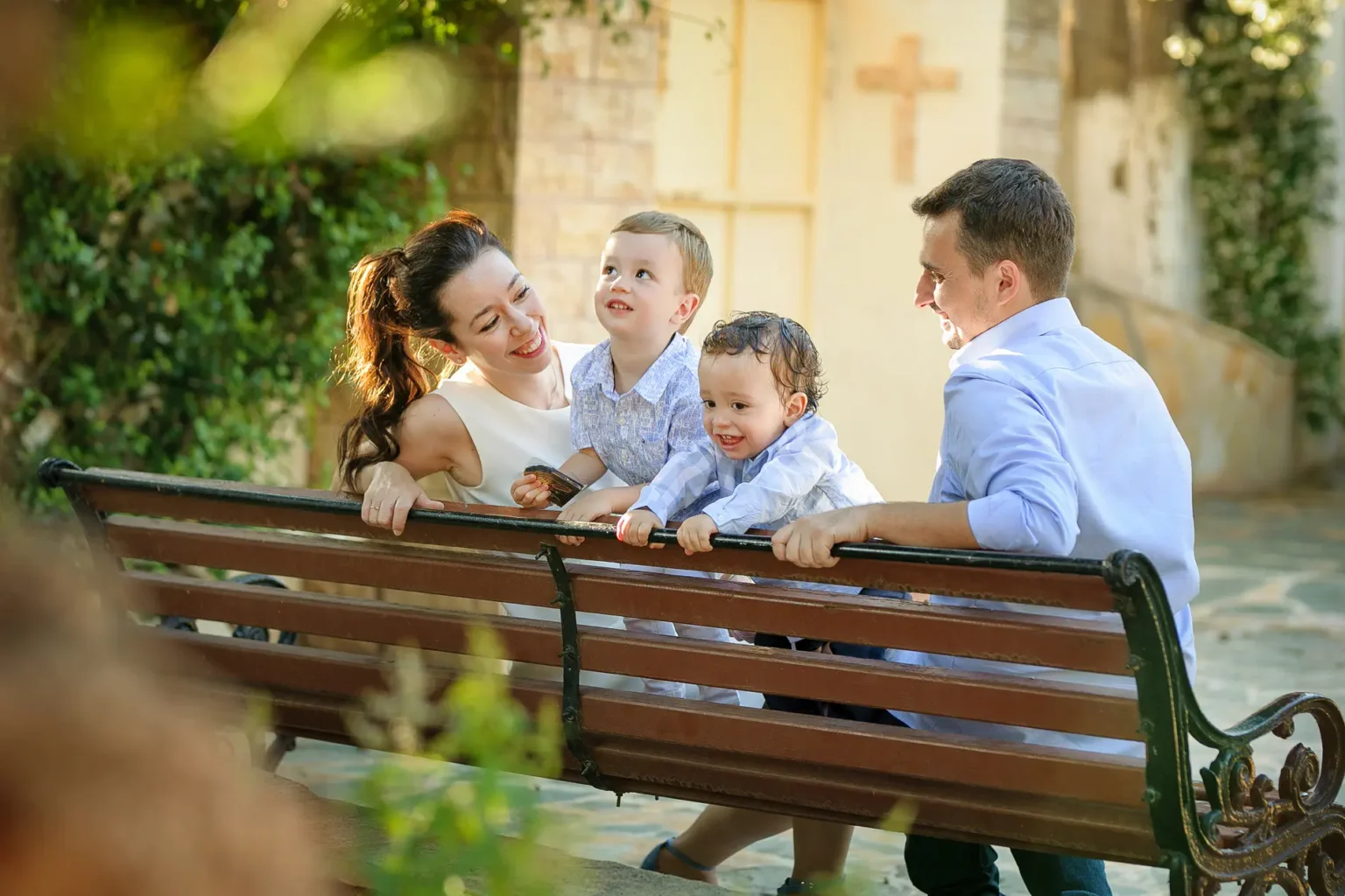 a man and woman with two children on a bench