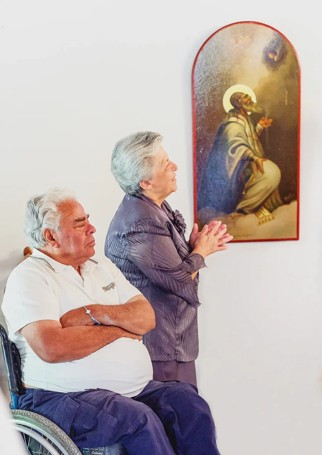 a man and woman praying in front of a painting