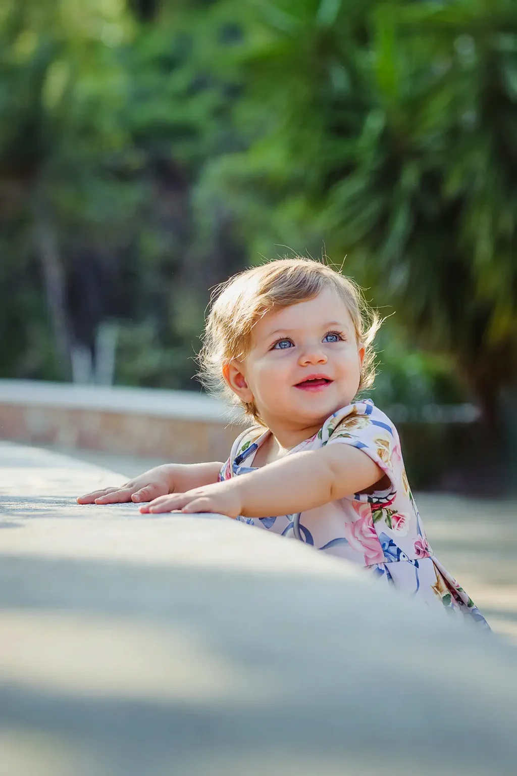 a baby girl leaning on a ledge