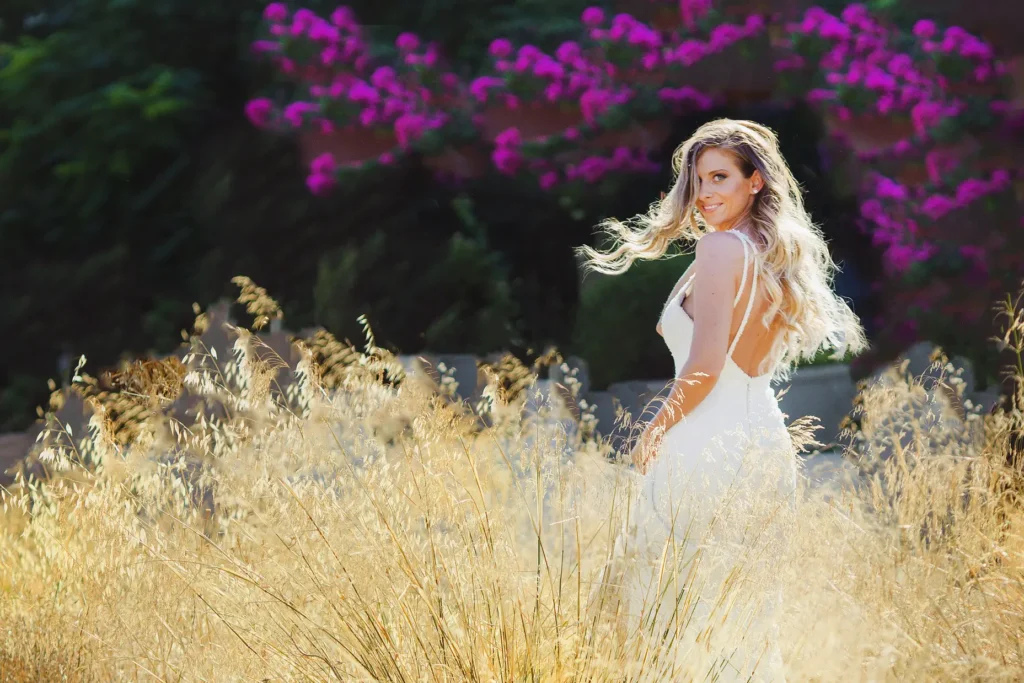 a woman in a white dress in a field of tall grass