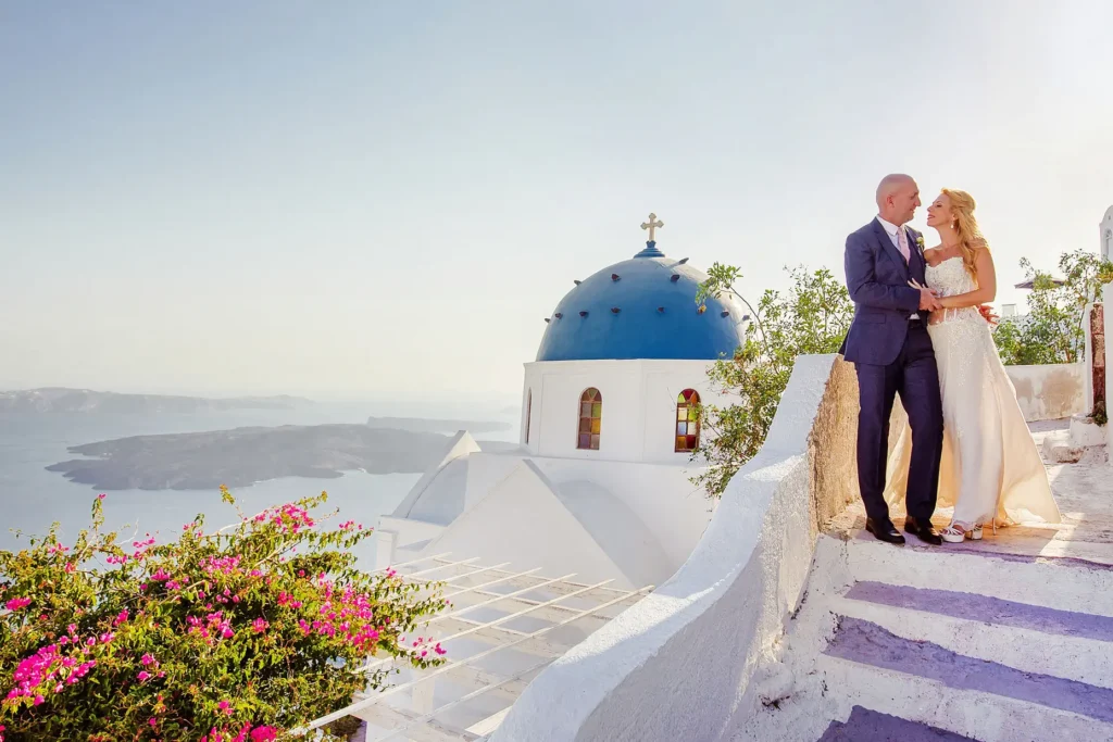 a couple of men standing on a stone wall overlooking a church