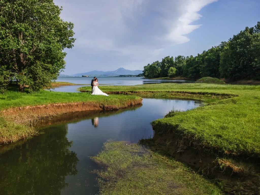 a bride and groom in a wedding dress by a river
