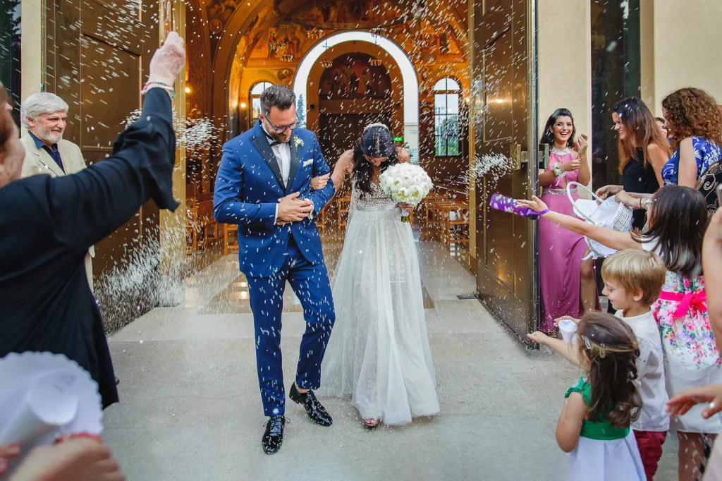 a man and woman walking down a aisle with confetti