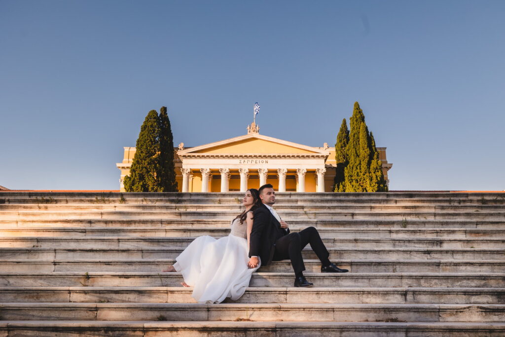 Νιόπαντρο ζευγάρι κάθεται πλάτη με πλάτη στα σκαλιά του Ζαππείου Μεγάρου στην Αθήνα